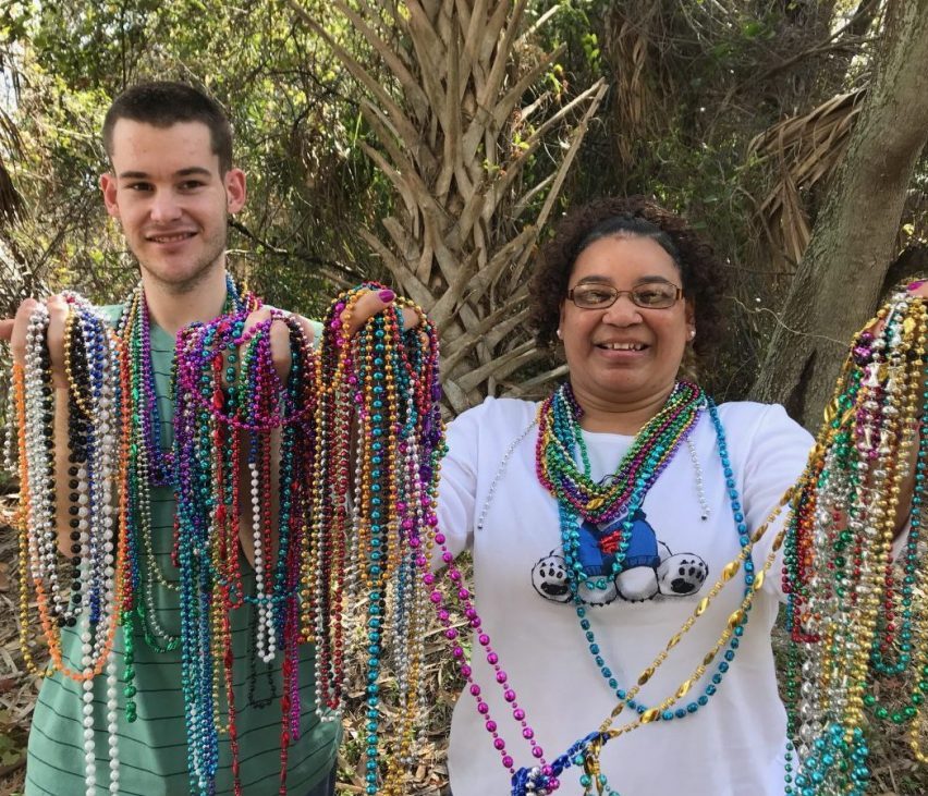 two people holding party beads