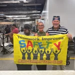 Ketta, Manu and John holding Safety Banner - Celebrating one Year Accident Free